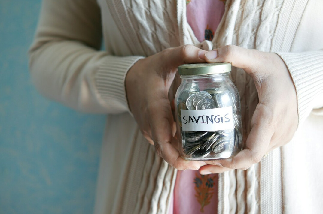 person saving money in jar